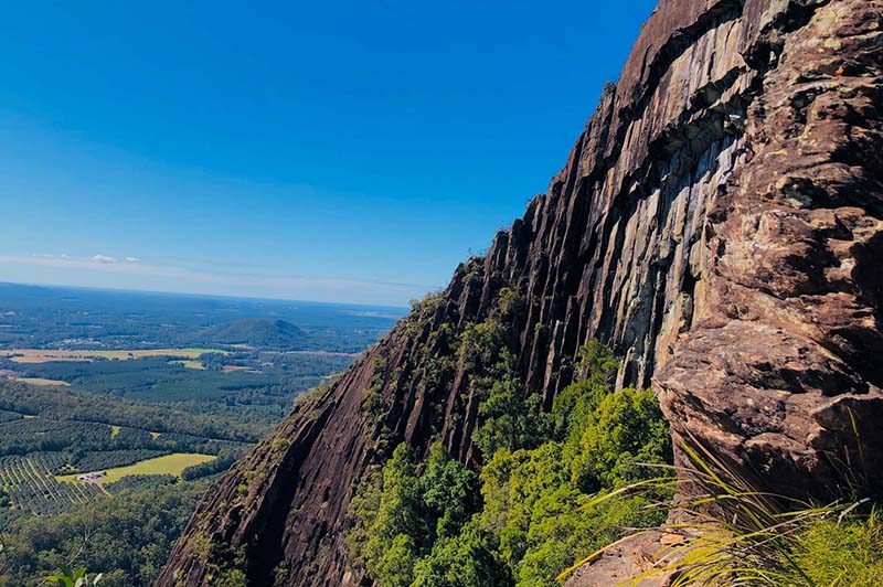 Sheer rock face with view of the Beerwah Conservation Reserve