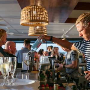 bartender pouring wine at noosa boathouse bar